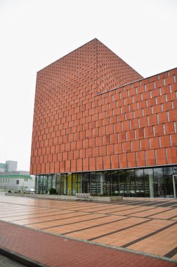 Modern bir binanın dar pencereli kırmızı tuğla cephesi, modern mimari