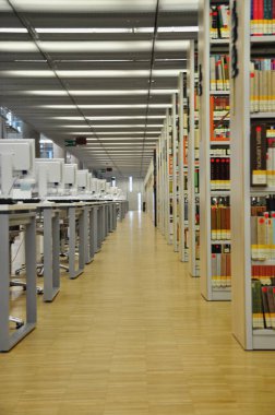 Modern bir kütüphane şehrinde uzun bir sırada sıralanmış beyaz bilgisayar monitörleri