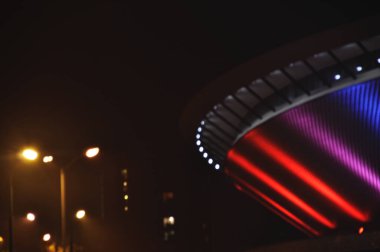 Illuminated in red and blue, the Spodek in Katowice, Poland clipart