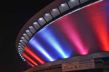 Illuminated in red and blue, the Spodek in Katowice, Poland clipart