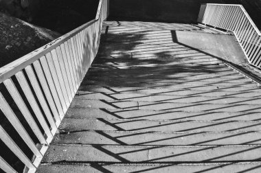 Merdivenlerin tek renkli fotoğrafı, merdivenlerden dökülen gölgelerin yakın çekimi siyah ve beyaz.