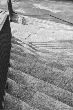 Merdivenlerin tek renkli fotoğrafı, merdivenlerden dökülen gölgelerin yakın çekimi siyah ve beyaz.