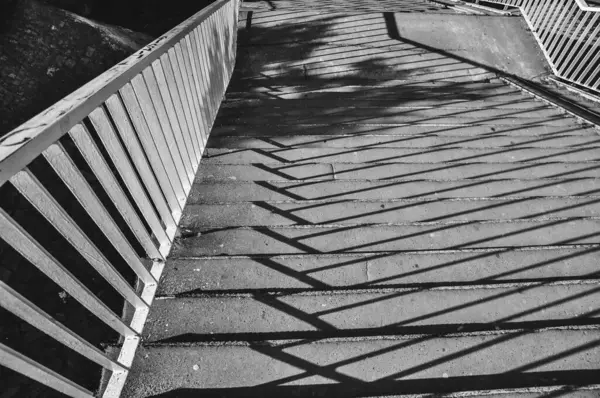 Merdivenlerin tek renkli fotoğrafı, merdivenlerden dökülen gölgelerin yakın çekimi siyah ve beyaz.