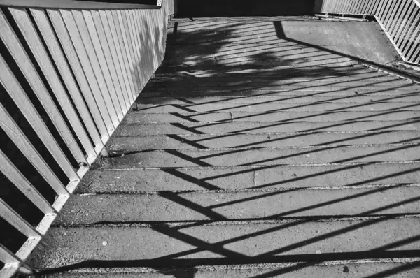Merdivenlerin tek renkli fotoğrafı, merdivenlerden dökülen gölgelerin yakın çekimi siyah ve beyaz.