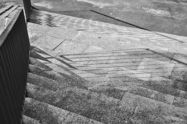 Merdivenlerin tek renkli fotoğrafı, merdivenlerden dökülen gölgelerin yakın çekimi siyah ve beyaz.