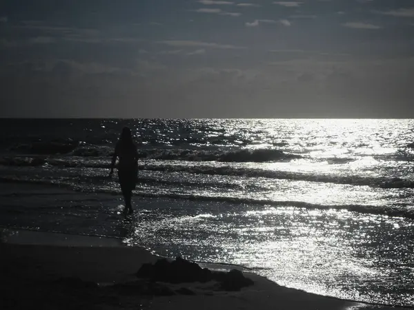 Güneş batarken Baltık Denizi kıyısında hafif bulutlu ve hafif dalgalı bir Polonya plajı.