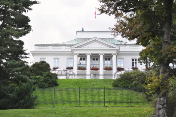 Varşova 'nın Kraliyet Azienki Parkı' ndaki göletin sakin manzarası, canlı Japon fenerleriyle süslenmiş tarihi bir köprü içeriyor. Sahne, sakin bir park ortamında Polonya ve Japon kültürlerinin uyumlu bir karışımını yakalıyor.