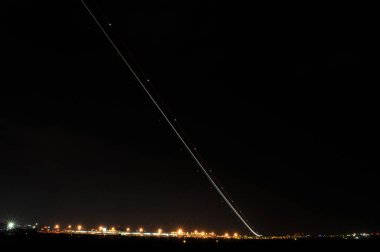 Bu dramatik fotoğraf bir uçağın gece kalkışını yakalar, yükselişini büyüleyici uzun bir ışık yoluna dönüştürmek için uzun pozlama tekniğini kullanır. Soyunma ışıkları, uçağın hareket ve hızını vurguluyor.