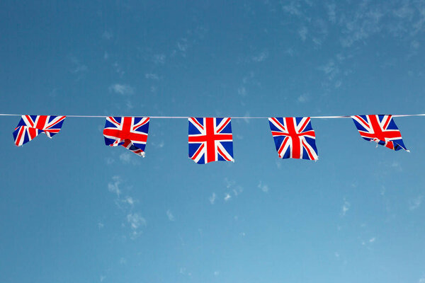 Union jack flag bunting against a blue sky