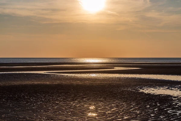 stock image Sun shining on the water and sand at sunset, at Formby beach on the Merseyside coast