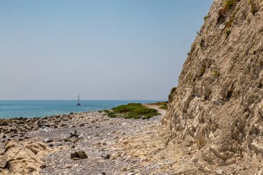 Sussex 'te Beachy Head yakınlarındaki engebeli sahil şeridine bakıyorum. Okyanusta bir yelkenli teknesi var.