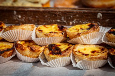 Pastels de nata, sığ bir alan derinliği olan bir fırında satılıktır.