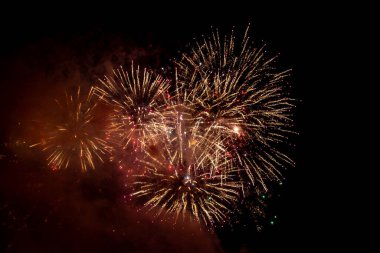 Gece gökyüzüne karşı patlayan havai fişeklere bakıyorum.