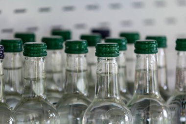 Satılık cam su şişelerinin sığ bir alan derinliğiyle yakın plan görüntüsü.