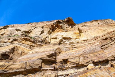 Sussex 'teki Pett Level' deki kayalıkların alçak açılı görüntüsü, yukarıda mavi bir gökyüzü var.