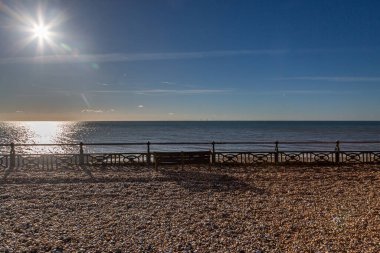 Hove sahilinde bir kış gününde, üzerinde mavi bir gökyüzü olan çakıl taşları.