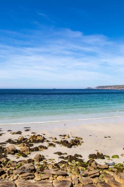Cornish sahilinde, güneşli bir yaz gününde Sennen 'de kumlu bir plaj manzarası.
