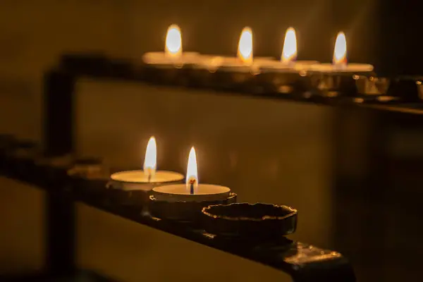 Lit tea lights in a church, with a shallow depth of field