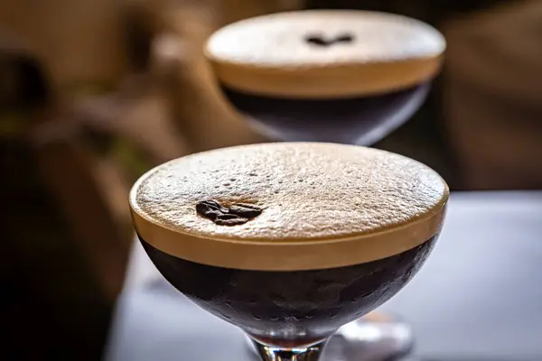 A close up of two Espresso Martini drinks, with focus on foreground
