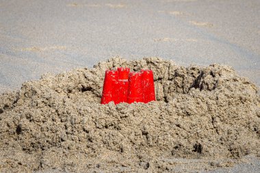 Cornwall, Sennen 'deki kumlu sahilde bir kum yığını ve bir çocuk kovası.