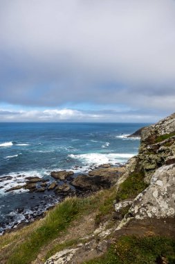 Güneşli bir yaz gününde, kayalık Cornish kıyısı boyunca bir manzara.