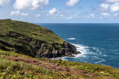 Cape Cornwall yakınlarındaki sahil şeridine bakıyorum, tepemizde mavi bir gökyüzü var.
