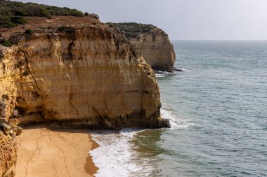 Portekiz kıyısındaki Ferragudo yakınlarında, Praia do Torrado 'nun tenha plajı.