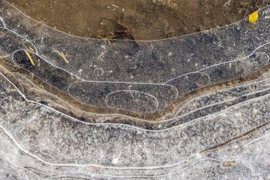 Kışın donmuş bir su birikintisinin tam kare fotoğrafı.