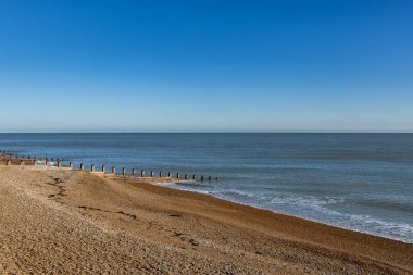 Güneşli bir kış gününde Sussex kıyısındaki Eastbourne 'da boş bir plajın manzarası.