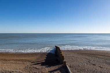 Güneşli bir kış gününde, Eastbourne 'daki çakıl taşı plajının üstünde bir manzara.