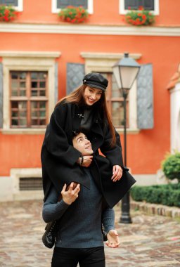 Komik kız oğlanın boynuna oturur. Mutlu çift eğleniyor, bahçede yürüyor..