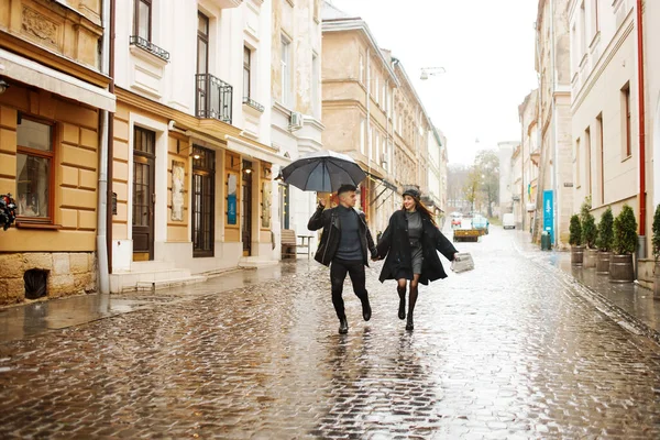 Joyeux Couple Courant Dans Rue Par Temps Pluvieux Tient Parapluie Images De Stock Libres De Droits