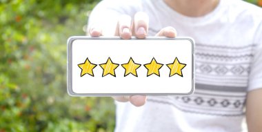 Ekranda arka planı bulanık olan beş yıldızlı çizim tarzı akıllı telefon. Hizmet derecesi, tatmin konsepti. Eleştiriler ve yorumlar Google haritaları. çevrimiçi geri bildirim