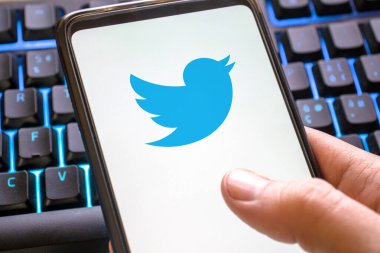 Mobil telefon mavi twitter simgesi renkli klavyede görüntüleniyor. Akıllı telefon kavramı sosyal ağ sembolü tweet 'i