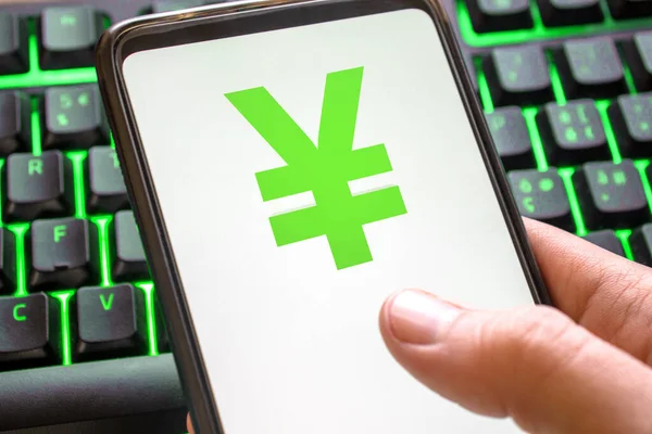 Smartphone with yen symbol on screen phone with technology green colored keyboard background