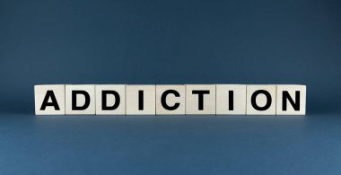 Tahta bloklar üzerinde ADDICTION kelimesinin kavramsal bir görüntüsü. Bu görüntü uyuşturucu bağımlılığı, alkol bağımlılığı, kumar bağımlılığı ve daha fazlası gibi çeşitli bağımlılıkları temsil etmek için kullanılabilir..