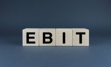 EBIT (Faiz ve Vergiden Önce Kazançlar) kavramını gösteren minimalist bir resim. EBIT sözcüğü ahşap bloklara yazılır, bir şirketin karlılığını değerlendirmek için kullanılan anahtar bir finansal metriği temsil eder.