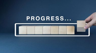 Bir görevi ya da projeyi bitirmeyi öneren odaklanmış bir görüntü. Tahta bloklar tamamlanmış bir ilerleme çubuğunun görsel bir temsilini oluşturur.