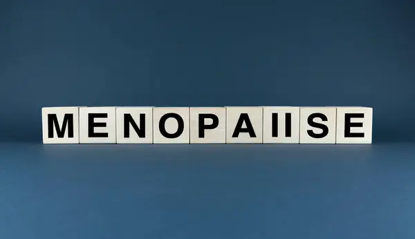 stock image A close-up of wooden blocks spelling out menopause. The image symbolizes the start of a new chapter in a woman's life, filled with wisdom and strength