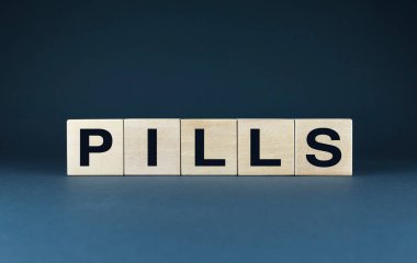 Tahta bloklar PILLS yazım blokları. Bu resim, reçeteli uyuşturucu kavramını ve bunların sağlık hizmetlerindeki rolünü sembolize etmektedir