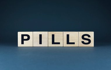 Tahta bloklar PILLS yazım blokları. Bu resim, reçeteli uyuşturucu kavramını ve bunların sağlık hizmetlerindeki rolünü sembolize etmektedir