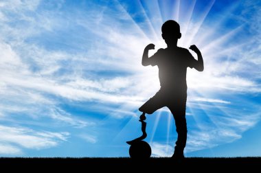 A young disabled boy with a prosthetic leg defies limitations by standing tall and proud with his foot on a ball. The image is a powerful reminder that anything is possible with determination and perseverance. clipart