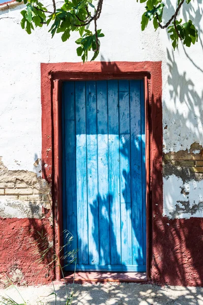 Old blue door of a rustic farmhouse or orchard house in the rice paddies of the Ebro Delta natural park, Tarragona; Catalonia; Spain