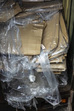 Karton, karton kutu ve geri dönüşüm için istiflenmiş plastik konteynır.