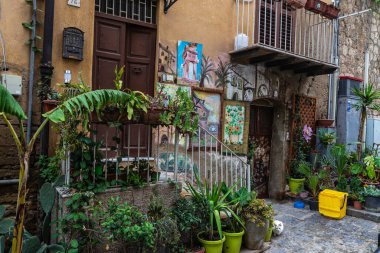 Agrigento, İtalya - 8 Mayıs 2023: Tablolu eski bir ev ve İtalya 'nın Sicilya kentindeki eski Agrigento kentinin dar bir caddesinin girişinde beyaz bir kedi