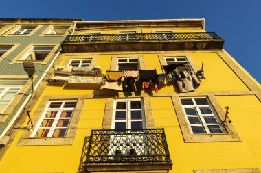 Eski Porto ya da Oporto, Portekiz 'de asılı giysileri olan eski klasik sarı bir binanın cephesi.