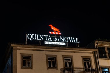 Oporto, Portugal - November 24, 2023: Illuminated logo and sign of the Quinta do Noval cellar, brand of Port wine, at night in Vila Nova de Gaia, Porto or Oporto, Portugal clipart