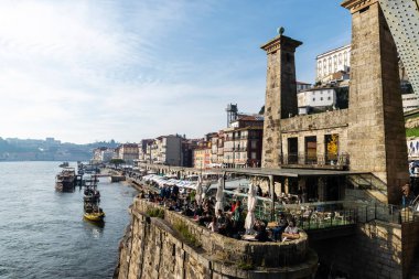 Oporto, Portekiz - 26 Kasım 2023: Oporto ya da Portekiz 'deki Douro nehri kıyısındaki Ribeira bölgesinde içki içen insanların olduğu bir barın terası