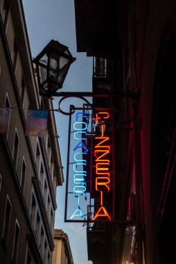 Gece Torin 'de, Torino' da, Piedmont 'ta, İtalya' da bir sokakta parlayan neon pizza ve odaklanma işaretleri.