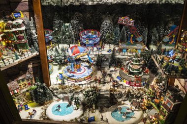 Torino, İtalya - 26 Kasım 2024: Torin veya Torino, Piedmont, İtalya 'da bir alışveriş caddesinde içinde minyatür eğlence parkı bulunan bir Noel süsü bulunan bir dükkanın sergilenmesi